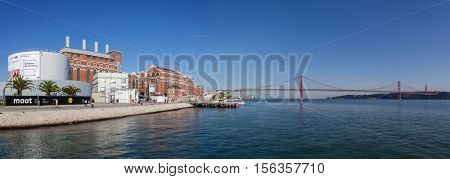Lisbon, Portugal - October 31, 2016: The Central Tejo, the historical power plant, currently the Electricity Museum and the 25 de Abril bridge spanning over the Tagus River.