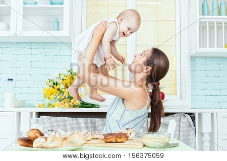 Mom holding the baby and he smiles.