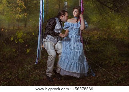 Man kissing woman's shoulder they are in retro vintage costumes.
