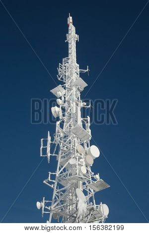 Communication transmitter tower with thick ice layer frost in cold winter