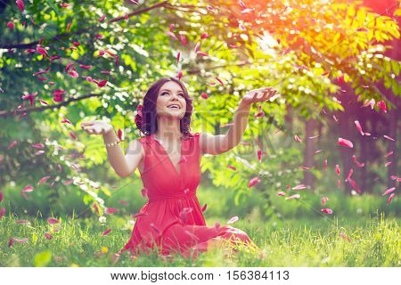 Beautiful girl on the nature in the park. Against the background of the summer lanshaft. Young romantic woman in the sunshine, sunset.