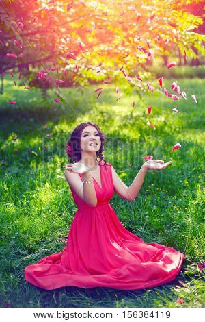 Beautiful girl on the nature in the park. Against the background of the summer lanshaft. Young romantic woman in the sunshine, sunset.