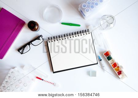 doctor workplace with blank open notebookat lab top view on white background
