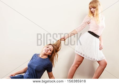 Aggressive mad women fighting each other pulling hair. Two young girls struggling win catfight. Violence.