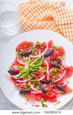 Grapefruit salad with olives red onion basil on the table