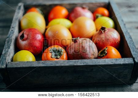 Different Fresh Citrus Fruit In A Basket On A  Wooden Background