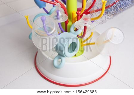 Baby drainer full of plastic tableware objects as baby bottles nasal aspirator milk bowls teats and others