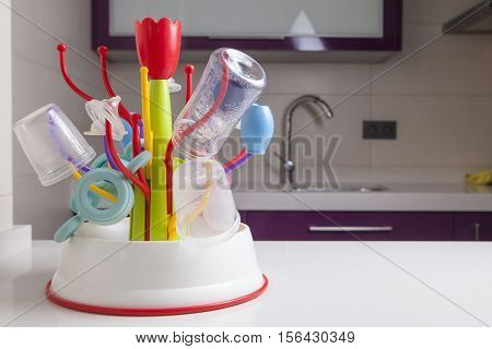 Baby drainer full of plastic tableware objects as baby bottles nasal aspirator milk bowls teats and others