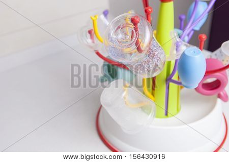 Baby drainer full of plastic tableware objects as baby bottles nasal aspirator milk bowls teats and others