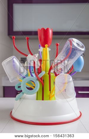 Baby drainer full of plastic tableware objects as baby bottles nasal aspirator milk bowls teats and others