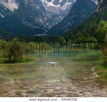 Drone flying over mountain lake. Alps, Italy