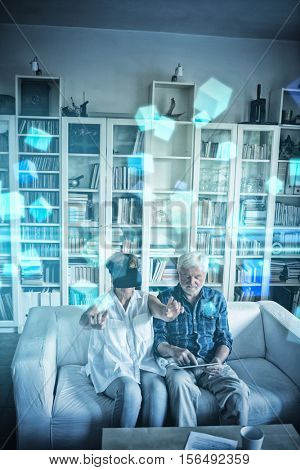 Futuristic screen with quaders against senior couple using digital tablet and virtual reality headset