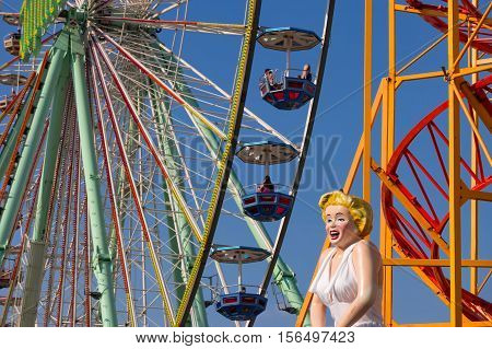 Closeup of a big observation wheel in the amusement park with the figure of Marilyn Monroe in the foreground. Bad Duerkheim, Germany - September 10 2016.
