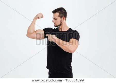 Fitness man shows on your biceps. isolared gray background