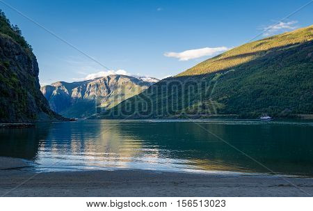 Sognefjord sand beach and mountains in Flam evening landscape. Flam, Norway.