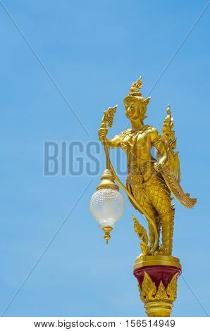 Thai kinaree mythology is a half woman and bird decorated in the lighting pole against blue sky.