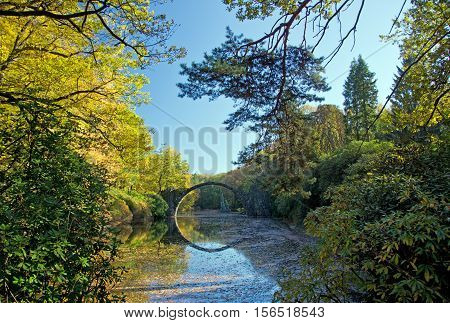 Arch Bridge in Kromlau, Saxony, Germany. Autumn in Park. Rakotz bridge in Kromlau