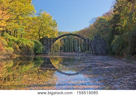 Arch Bridge in Kromlau, Saxony, Germany. Autumn in Park. Rakotz bridge in Kromlau