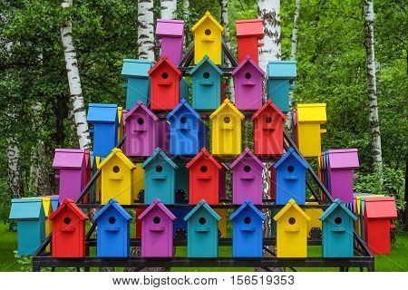 Stacked rows of colorful birdhouses. New multicolored nesting boxes in vintage style.