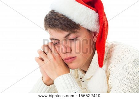 portrait of young guy in red senta hat with closed eyes isolated on white background