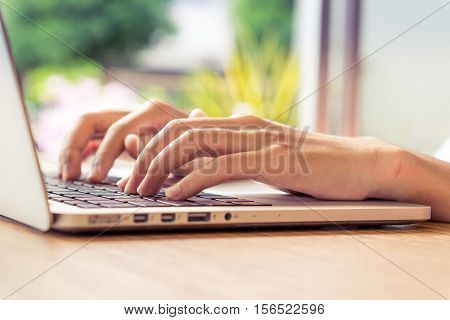 Put fingers on the keyboard of labtop with vintage style.