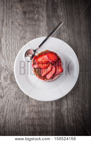 Strawberry and custard tart on a white plate.