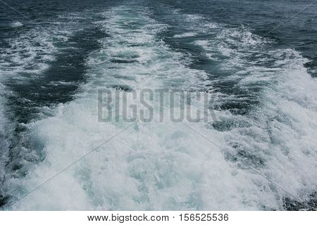Close up foam wave on sea from boat. nature background texture for graphic resource.