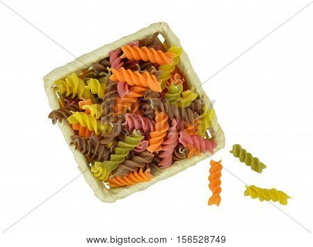 Colorful raw pasta in a basket. Top view. Ingredients. Isolation on a white background without shadows. Close-up.