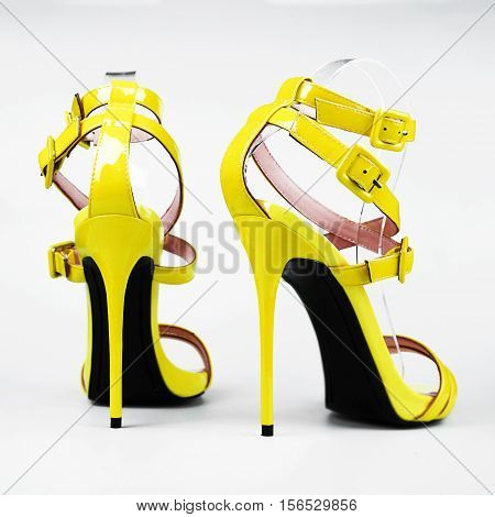 Fashionable yellow woman stiletto shoes on white background