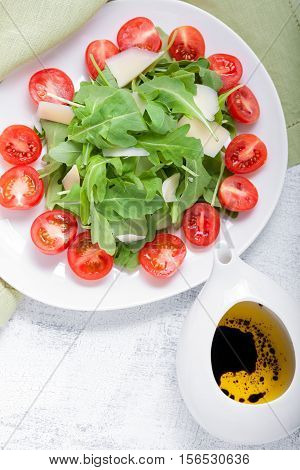 Salad with arugula, tomatoes served on the table