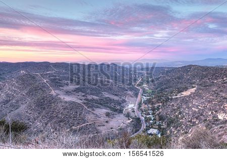 Laguna Canyon Road with Saddleback Mountains in the distance from Top of the World hiking trail in Laguna Beach at sunset