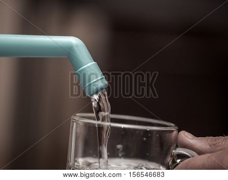 Water filter is poured into a transparent glass closeup
