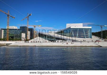 OSLO NORWAY - AUGUST 17 2016: Tourist on the Oslo Opera House which is home of Norwegian National Opera and Ballet and National Opera Theatre in Oslo Norway on August 172016.