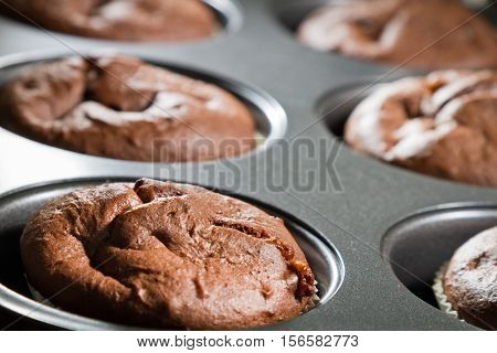 Closeup chocolate brown muffin in baking tray