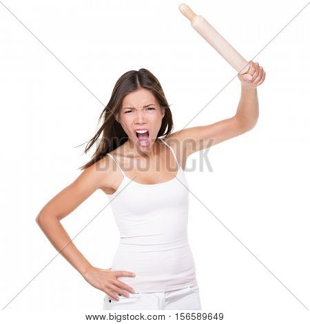Crazy upset housewife or chef woman holding up a rolling pin in anger threatening to hit in violence, isolated on white studio background. Funny negative expression Asian girl screaming at camera.