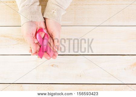 Womens health symbol in pink ribbon on wooden board.