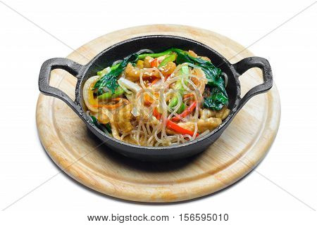 Korean rice noodle with vegetables on frying pan on white background