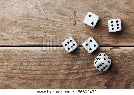 White dice on wooden table top view. Gambling devices. Game of chance concept.