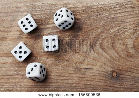 White dice on wooden table from above. Gambling devices. Game of chance concept.