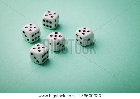 White dice on green background. Gambling devices. Copy space for text. All number five. Game of chance concept.
