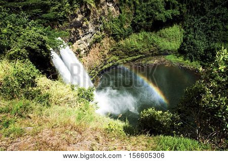 A waterfall in the jungle with double rainbow.