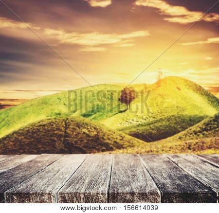 Wood terrace and perspective view on forest field or green hill in sunset, vintage tone