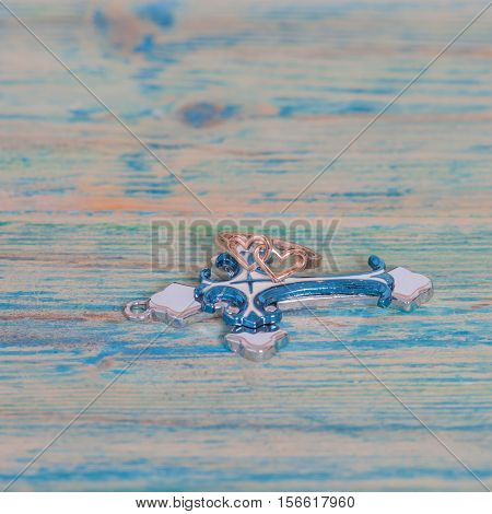 Wedding rings and coss on wooden table