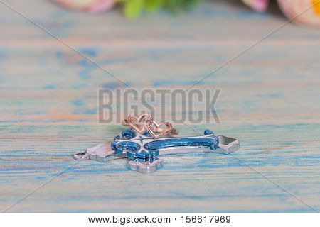 Wedding rings and coss on wooden table