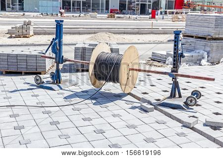 Cable spool is on the axle until worker unwinds wire.