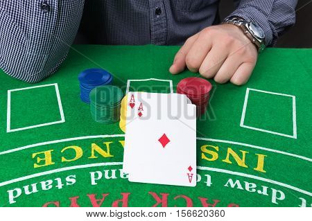 Casino chips and cards on green table. Two aces. Elegant business man. Gambling problems abstract concept.