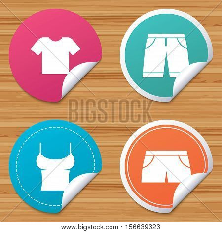 Round stickers or website banners. Clothes icons. T-shirt and bermuda shorts signs. Swimming trunks symbol. Circle badges with bended corner. Vector