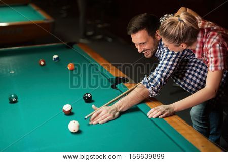 Couple dating and having fun playing snooker