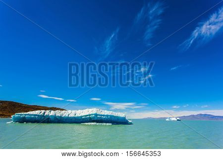 Argentina Patagonia, emerald water of the lake Viedma. Huge white-blue ice floe drifts from coastal glacier