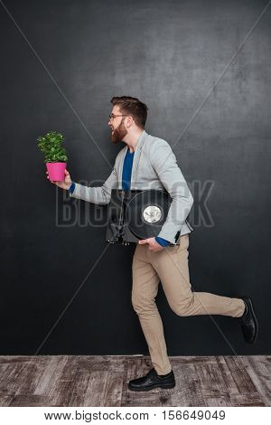 Guy with vynil and flower. in profile. full length portrait